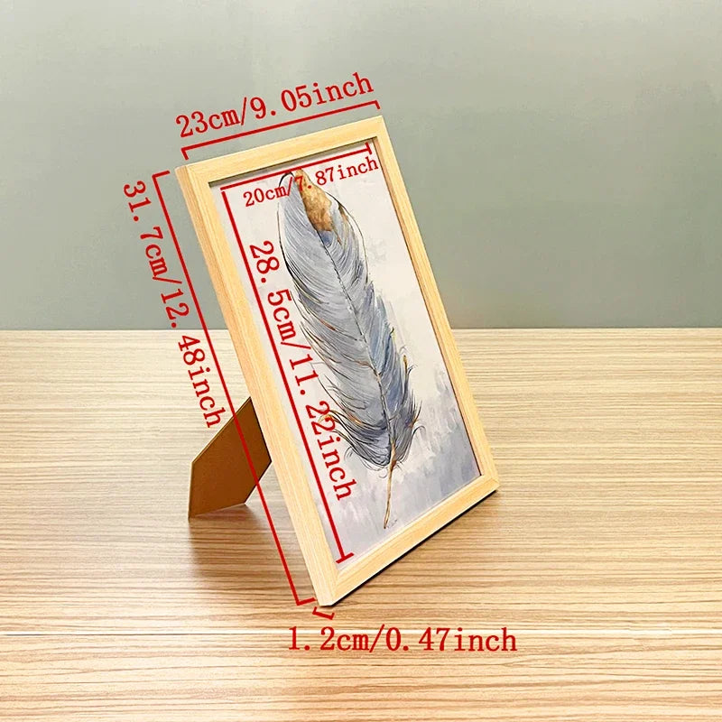 A wooden picture frame displaying a feather, shown with dimension lines.