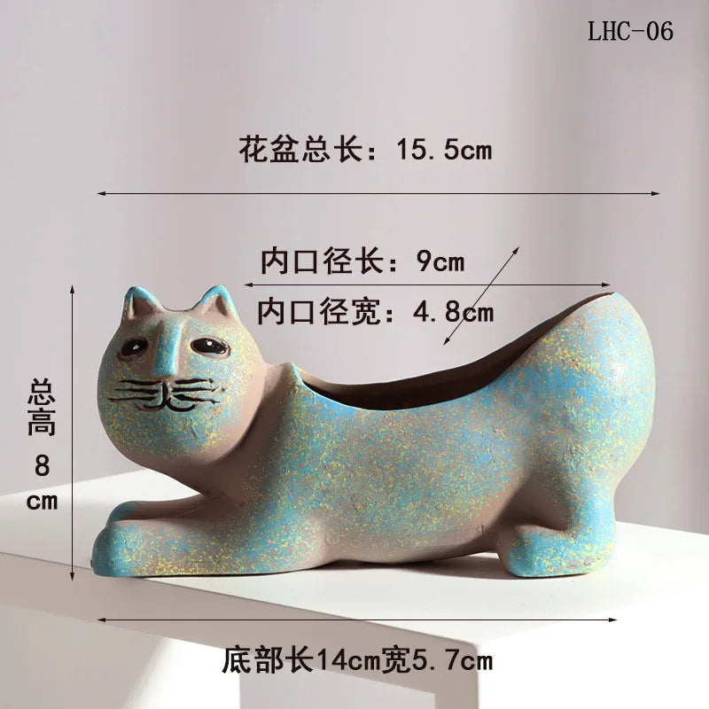 A ceramic succulent planter shaped like a cat, colored in iridescent blue and green, shown in profile.