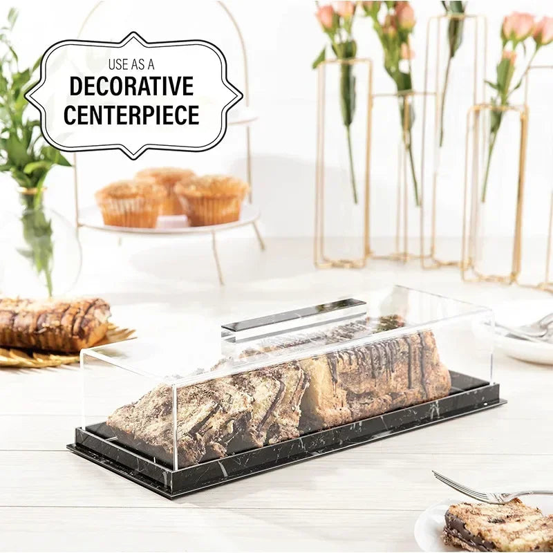 Clear acrylic cake stand with a lid displaying a rectangular marbleized dessert.