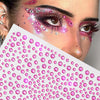 Close-up of a woman's face decorated with pink and clear glitter gems for facial tattoos