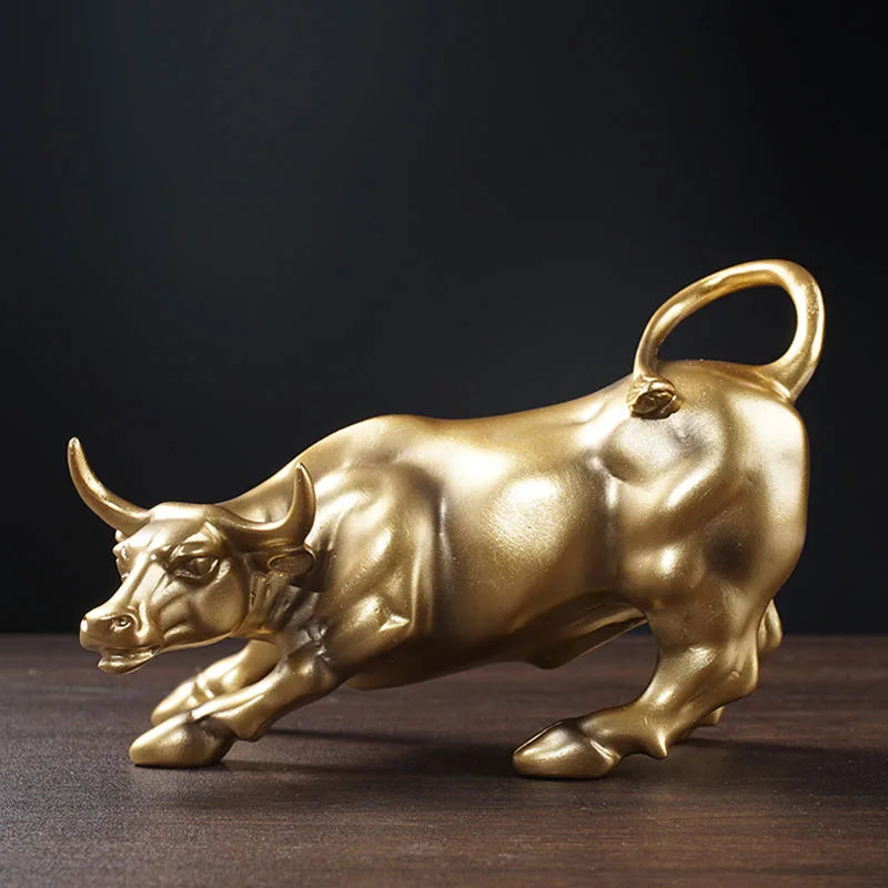A golden sculpture of a bull in profile against a dark background.