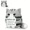 A gray knitted cat plush pendant with a card that reads Positive Cat You're Pure-fect