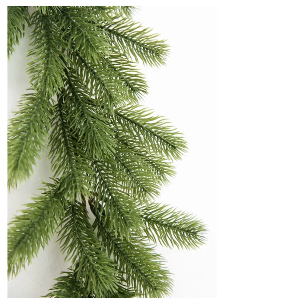 A close-up of a green artificial pine garland with long needles, suitable for holiday decorating.