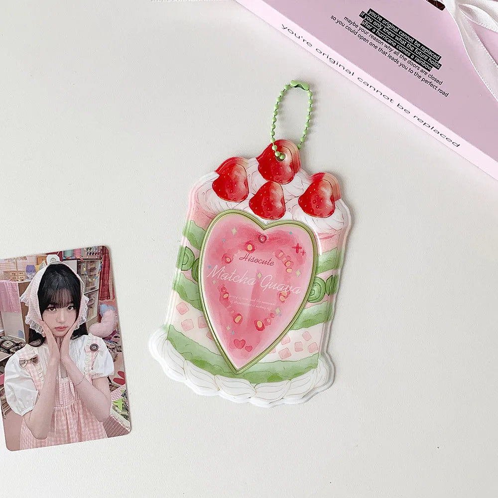 A pink and green cartoon strawberry bag keychain card holder with a heart design and red fruit accents.