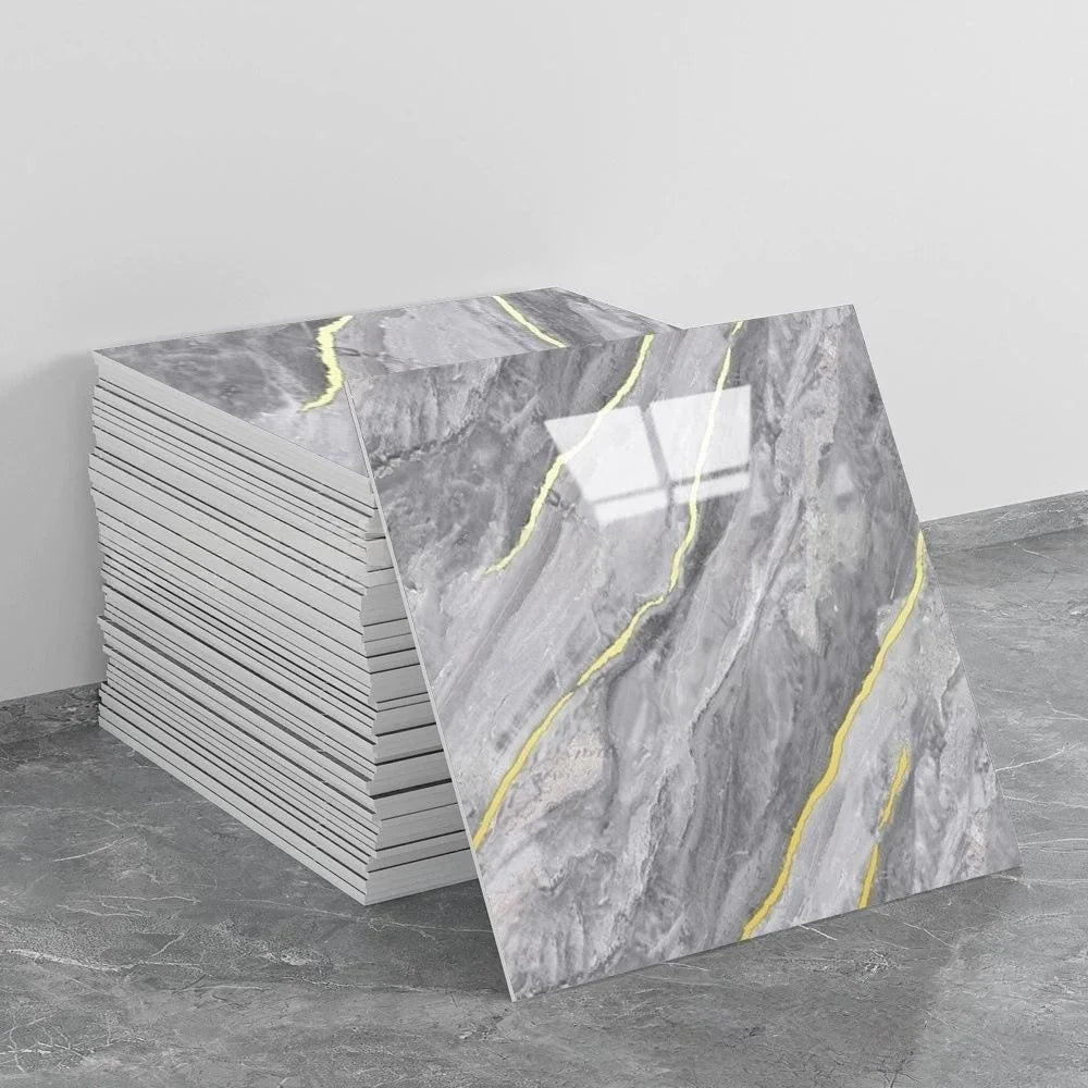 A stack of self-adhesive marble tile stickers featuring gray marble with yellow veining on a gray floor.