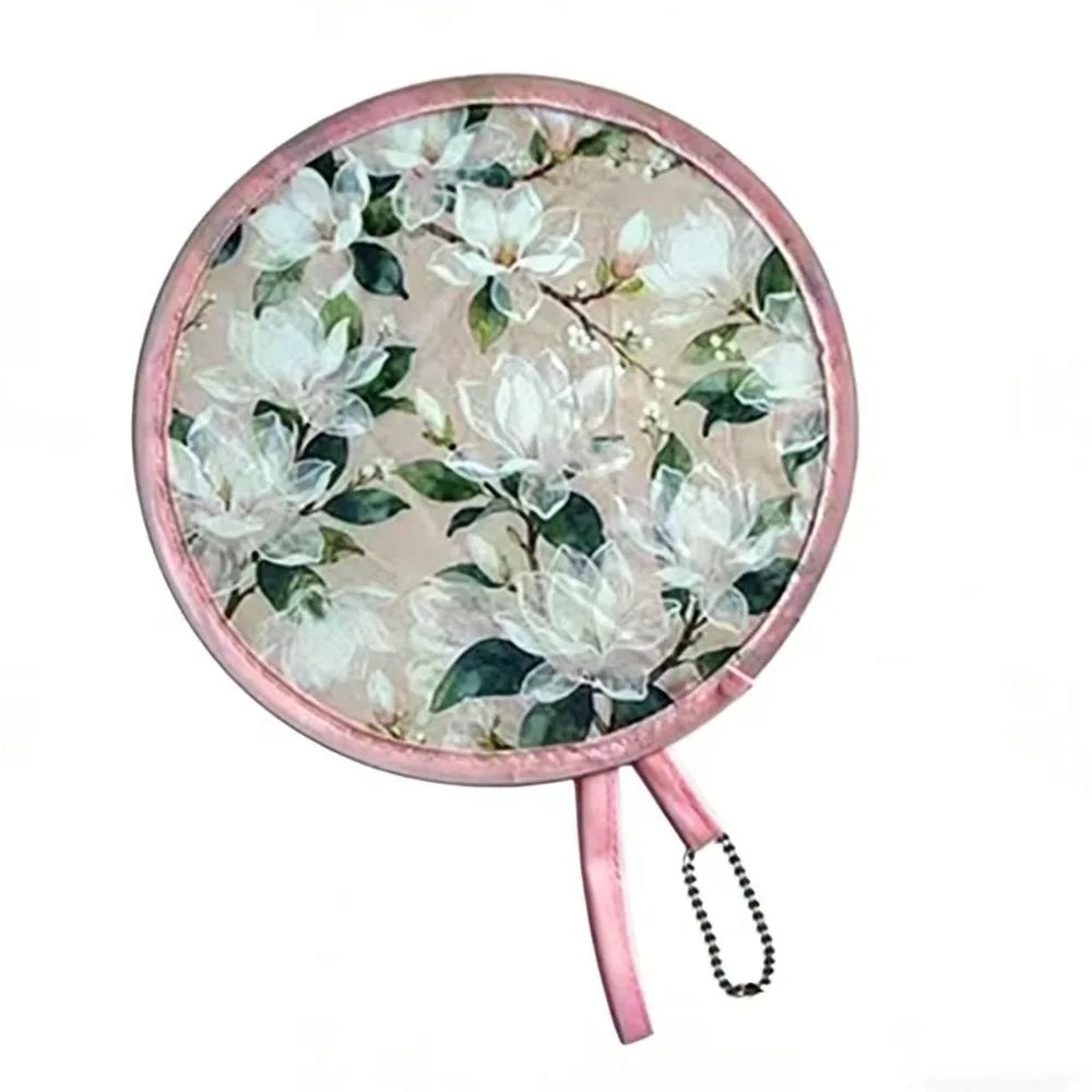 A round, pink-edged floral fan with white and green leaves.