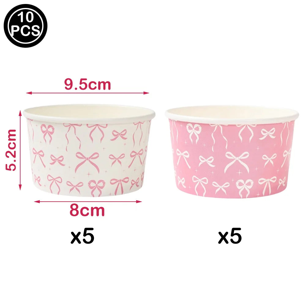 A set of ten pink cupcake toppers featuring decorative bows and streamers on white cups.