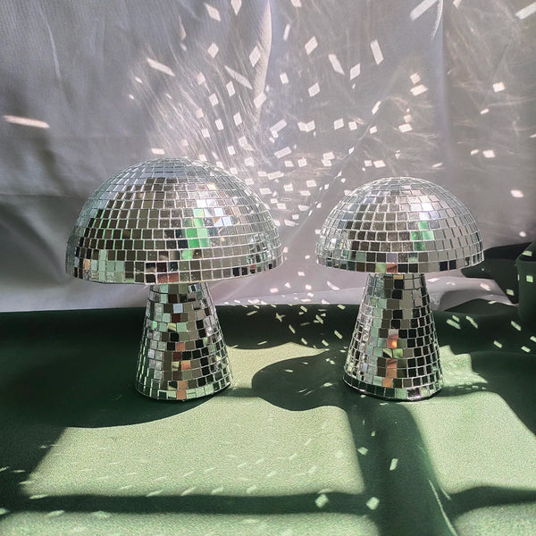 Two mushroom-shaped mirror disco ball decorations are displayed against a white background with light patterns.