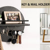 A black circular wall key and mail holder featuring a wooden shelf and decorative items.