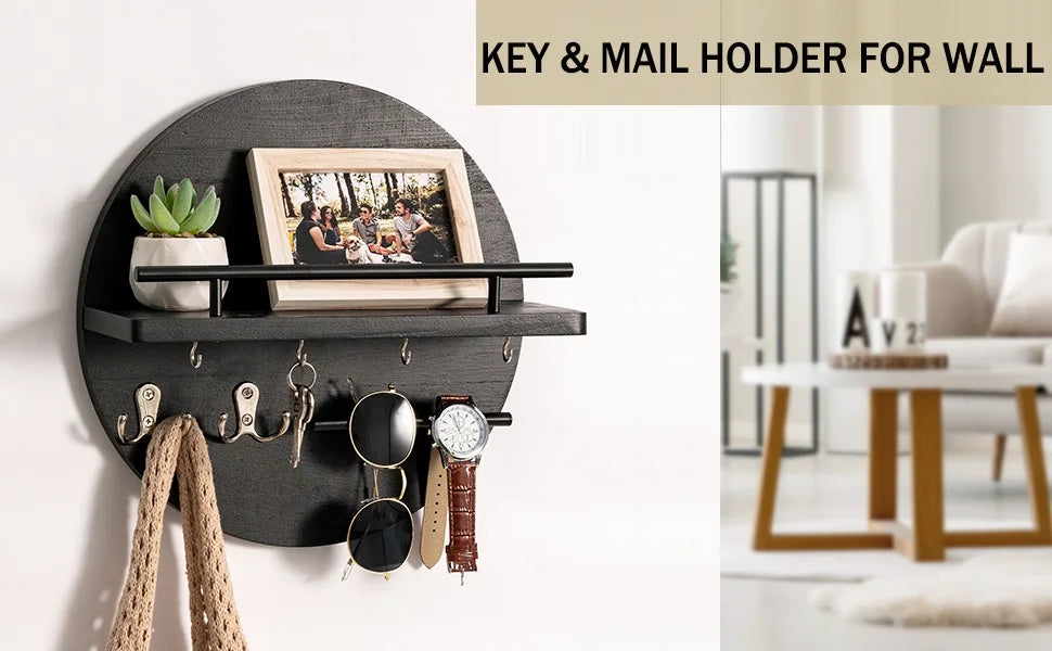 A black circular wall key and mail holder featuring a wooden shelf and decorative items.