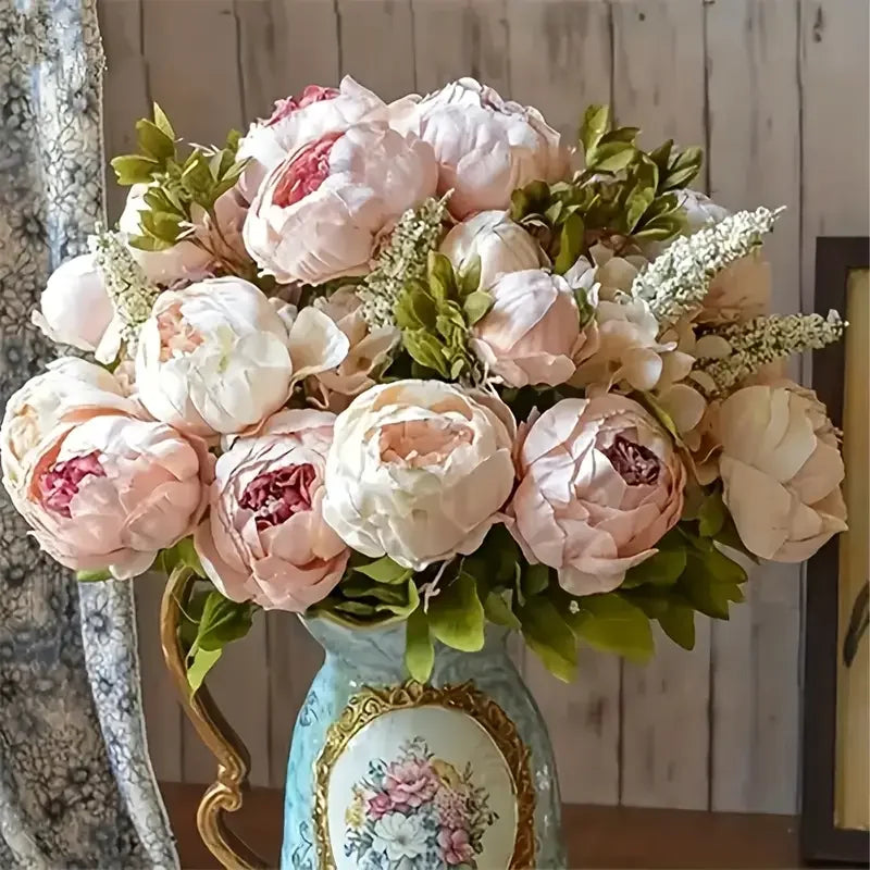 A bouquet of pink and cream peony artificial silk flowers arranged in a light blue vase.