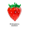 A red strawberry shaped balloon with green leaves and white dots.