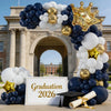 A balloon arch display featuring navy blue, white, and gold balloons shaped like a crown for a graduation event.