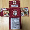 A handcrafted pocket shrine featuring a cross and various religious images on a dark red fabric background.
