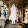 Una decoración fantasma de tela blanca cuelga en un porche, adornada con hojas de arce naranjas y murciélagos para Halloween.