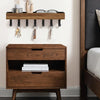 A rustic wooden floating shelf with hooks mounted on a wall above a dark wood storage box.
