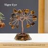 A Tiger Eye crystal tree featuring multiple natural stones branching out from a base on a white surface.