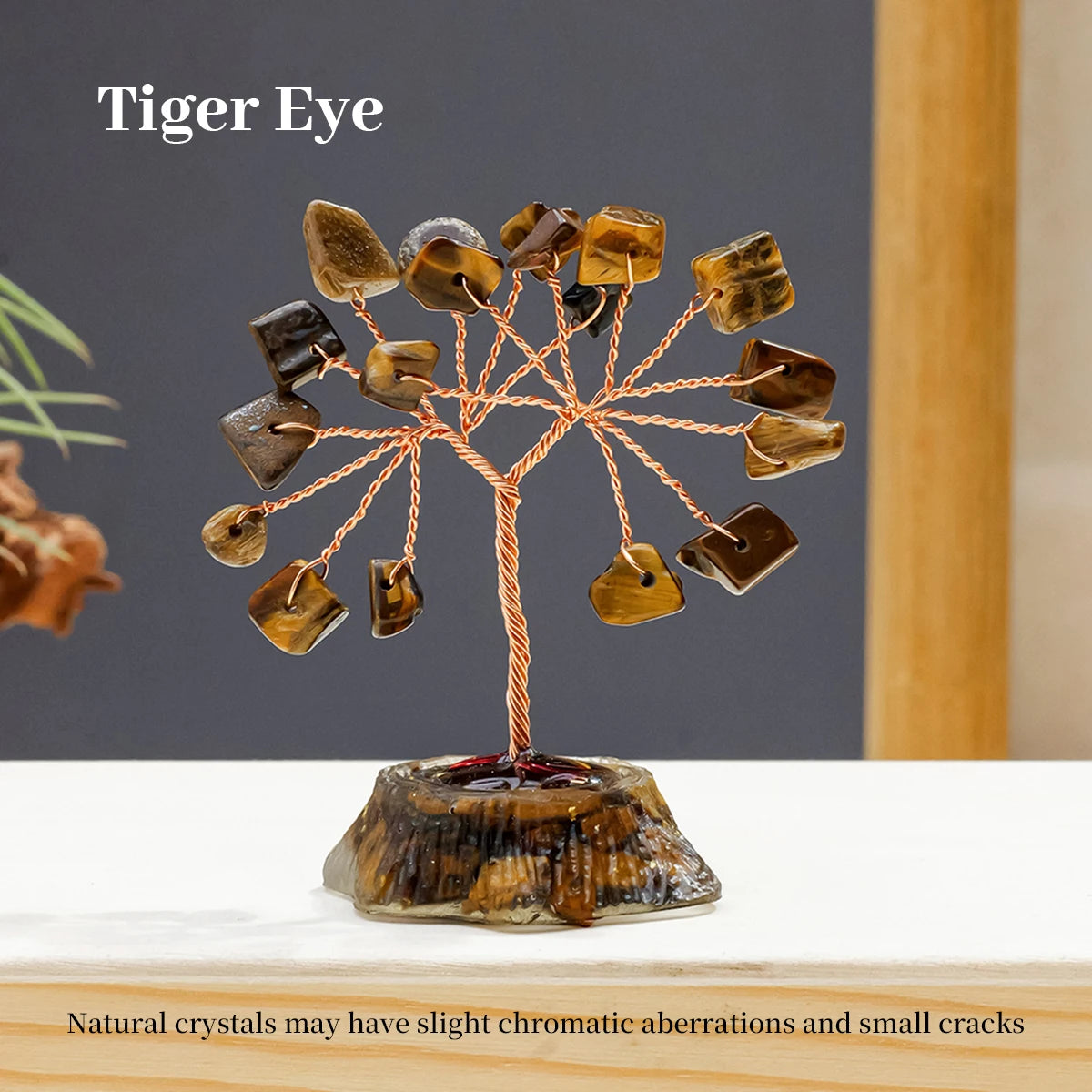A Tiger Eye crystal tree featuring multiple natural stones branching out from a base on a white surface.