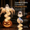 A glowing, layered fabric ghost figure in a swirling design illuminates a carved pumpkin for Halloween decor.
