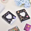 A black photo card album binder with a heart-shaped cutout and rainbow accents is displayed on a white surface.
