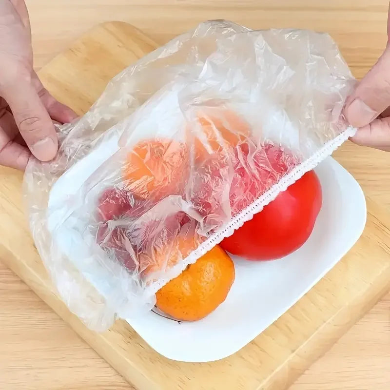 Reusable food storage bags filled with fresh tomatoes and citrus fruits on a white plate.