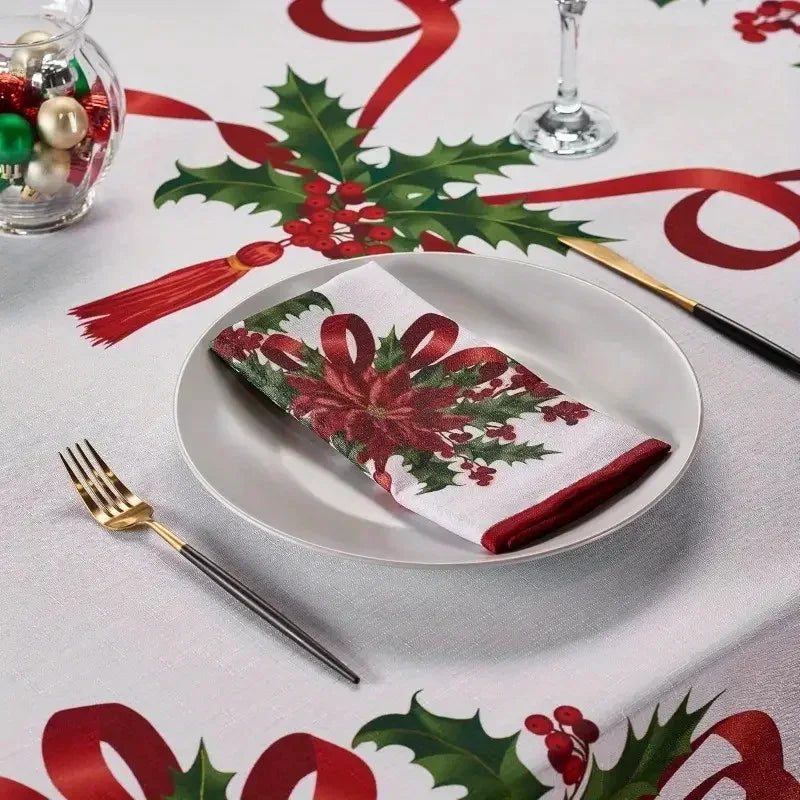 A white plate with a red and green poinsettia rectangle napkin set on a festive holiday tablecloth.