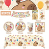 A set of birthday party decorations featuring a capybara theme including banners, balloons, and food items.