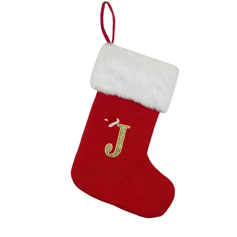 A red Christmas stocking with a white fluffy cuff featuring a gold letter J