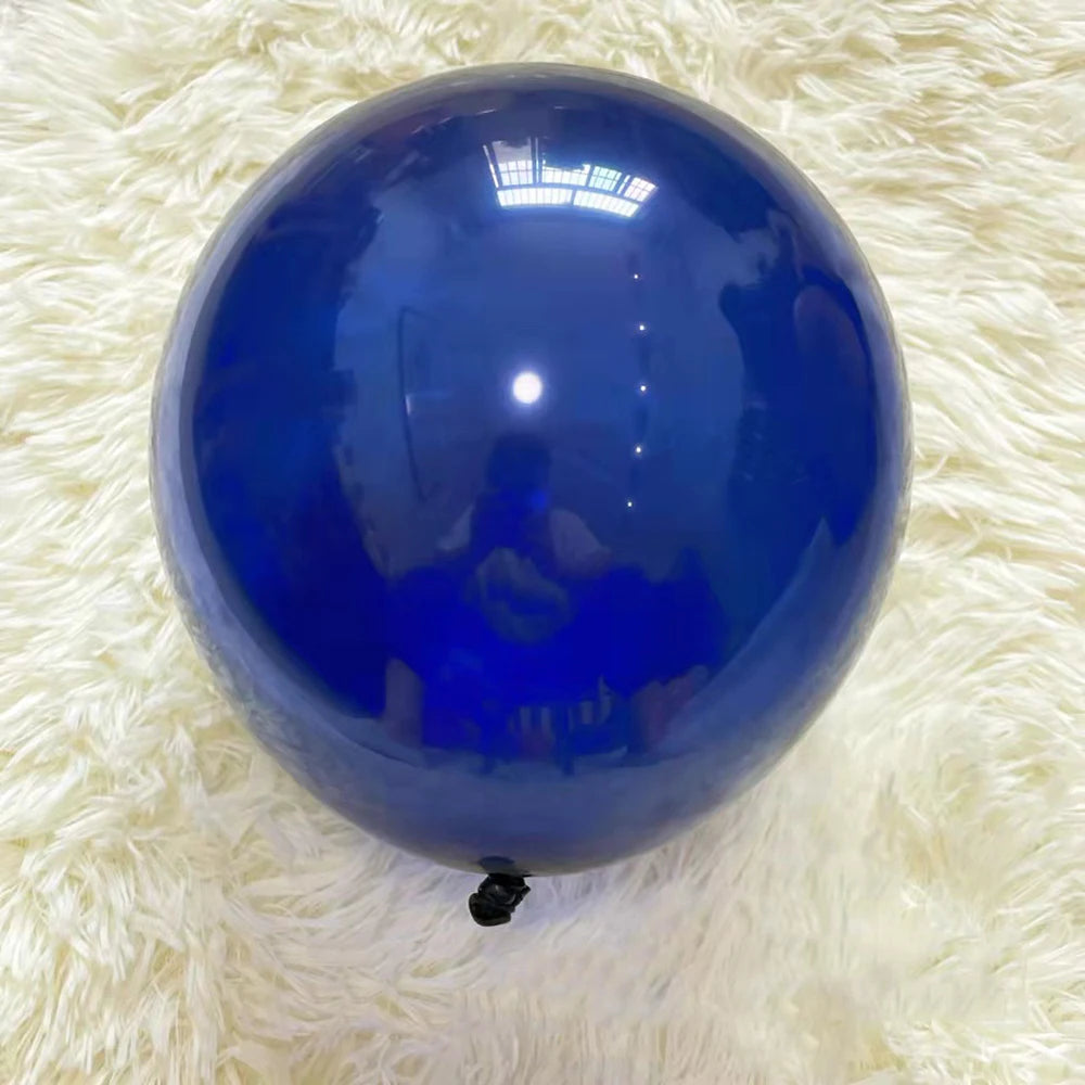 A glossy blue latex balloon resting on a white, fluffy surface.