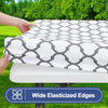 A white and gray geometric patterned waterproof elastic fitted tablecloth is being placed on a table.