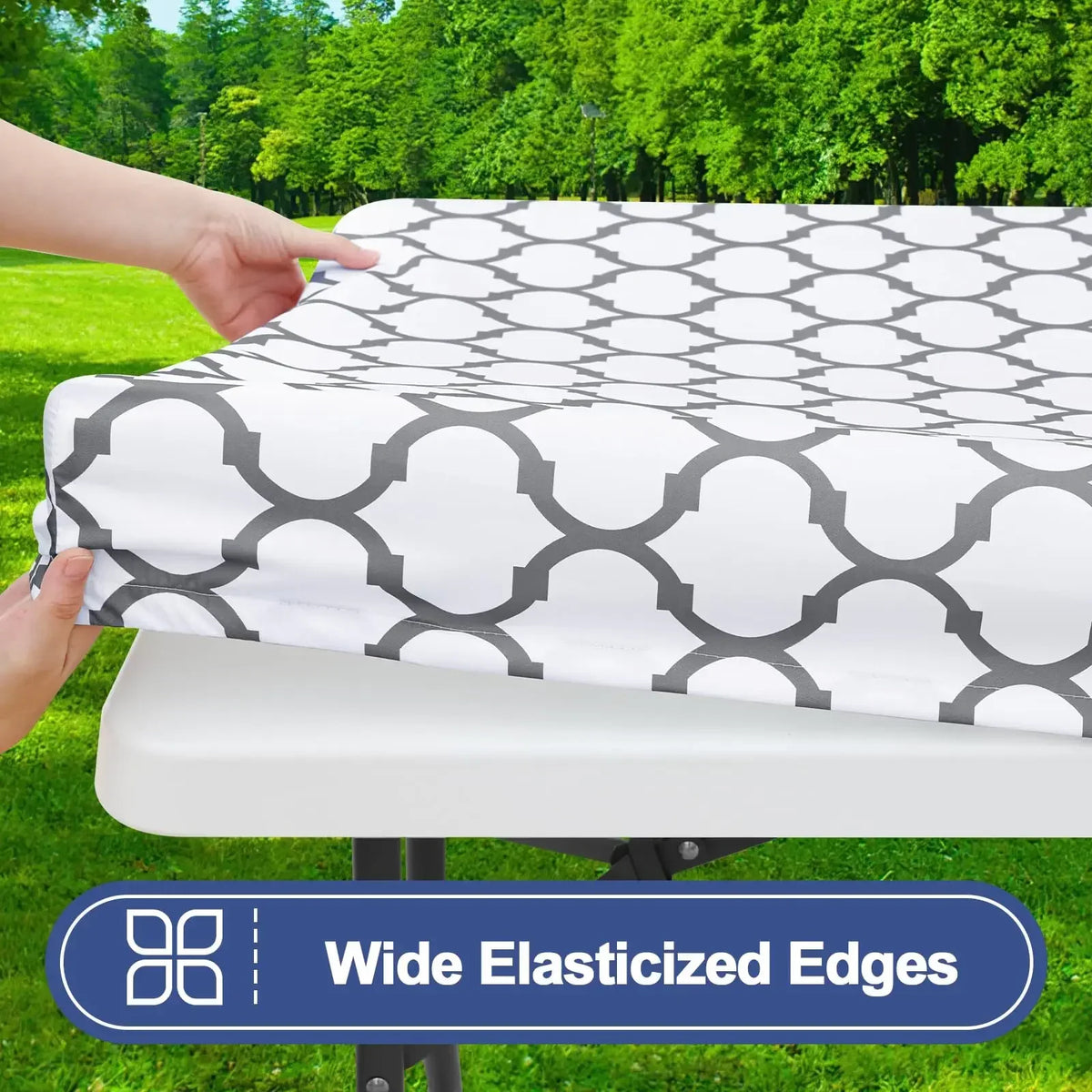 A white and gray geometric patterned waterproof elastic fitted tablecloth is being placed on a table.