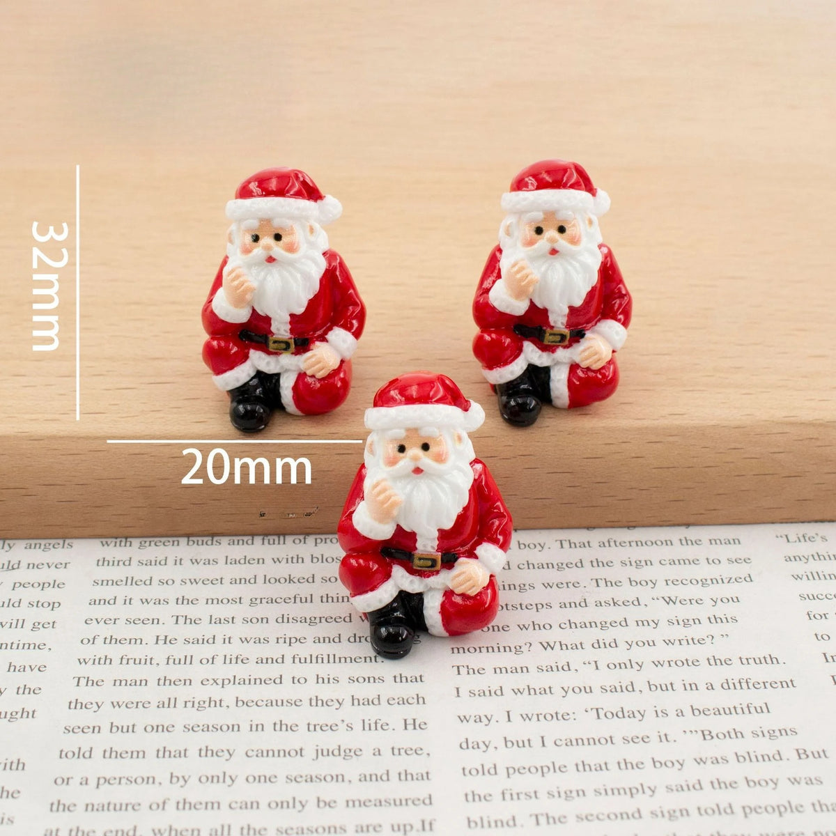 A set of festive Christmas resin decor featuring two Santa figures in red and white with beard and hat.