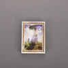 A framed painting featuring a woman under an umbrella in a field, displayed as a fridge magnet.