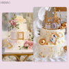 A tiered white cake decorated with pink roses and gold accents, next to a set of silicone frame molds.
