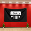 A black flag banner featuring the white Jeep logo mounted on a red wall.