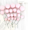 A set of twenty pink balloon cake toppers on thin green sticks with a handwritten message.