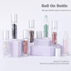 A set of ten glass roll-on bottles filled with various semi-precious stone roller balls displayed on a white surface.