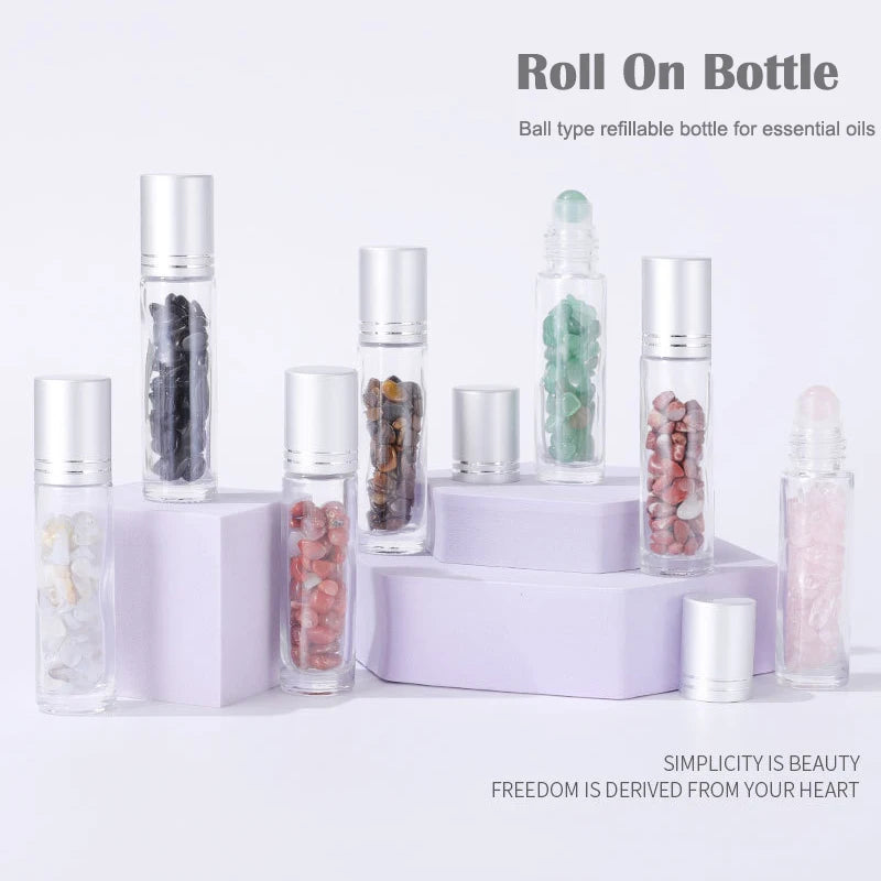 A set of ten glass roll-on bottles filled with various semi-precious stone roller balls displayed on a white surface.