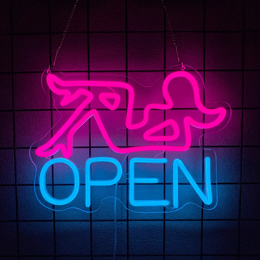A neon sign shaped like a stylized animal silhouette and the word OPEN glowing in pink and blue against a dark grid backgroun