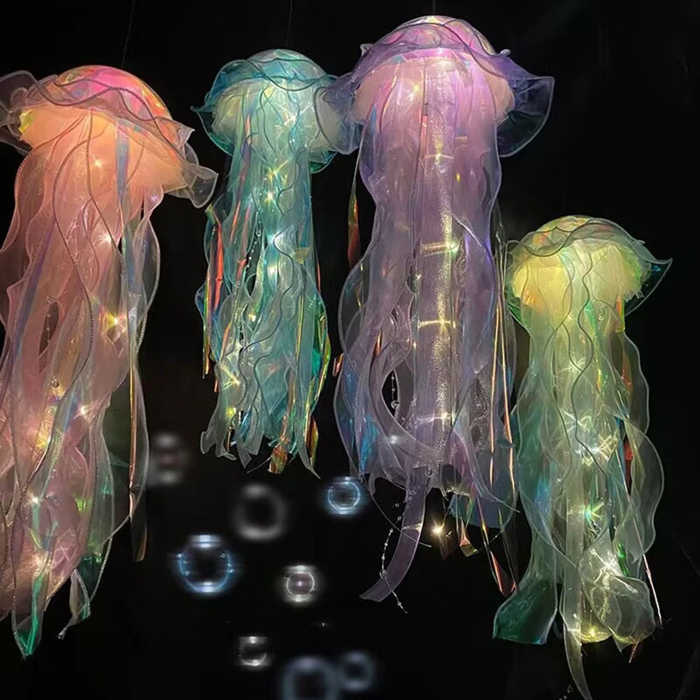 Three glowing jellyfish lanterns in pink, teal, and purple suspended against a dark background.