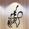 A black line art sculpture of a hand holding a cup with steam rising, mounted on a light-colored wall.