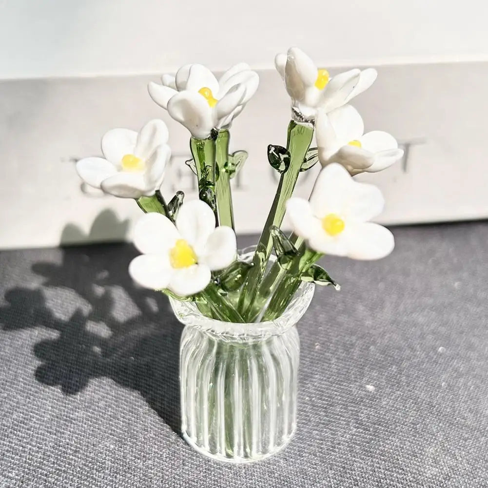 A bouquet of white and yellow flowers in a clear glass vase