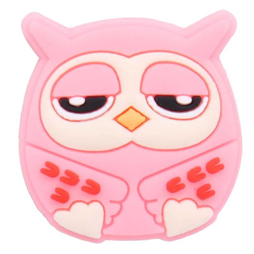 A pink owl shaped PVC shoe charm featuring large eyes and orange accents.