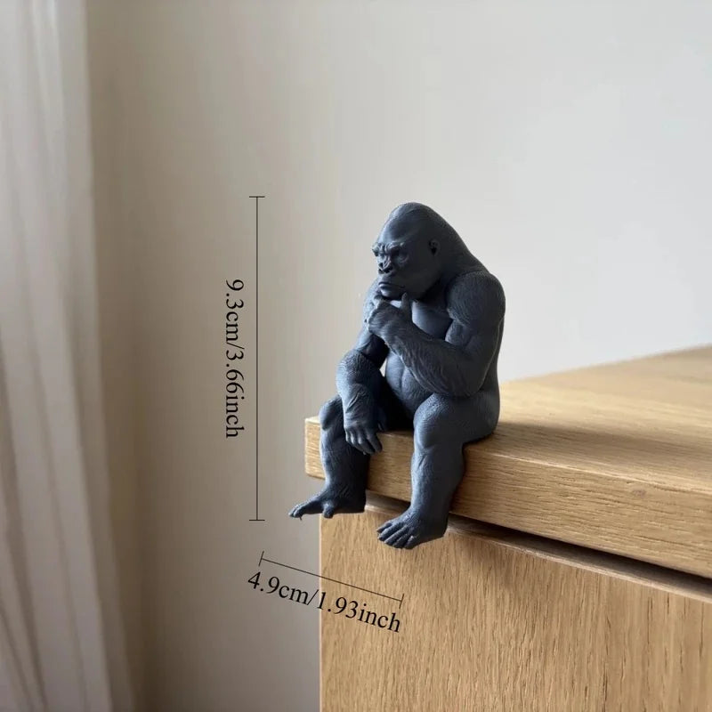 A dark gray 3D-printed gorilla figurine sitting on a wooden surface.