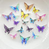 A collection of thirty colorful resin butterfly embellishments in various shades of blue, purple, and yellow arranged on a wh