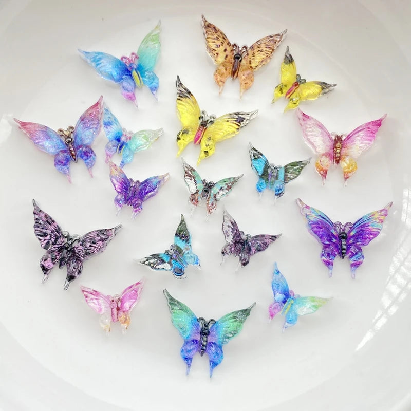 A collection of thirty colorful resin butterfly embellishments in various shades of blue, purple, and yellow arranged on a wh