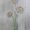 A large artificial silk purple and white poppy flower displayed on a green stand.
