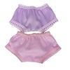 A set of lavender and pink satin doll outfit including a top and bottom piece with lace trim.