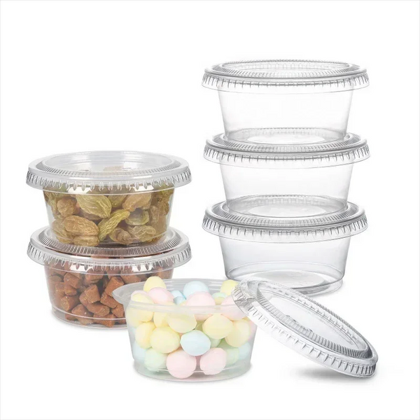 A collection of clear plastic sauce cups with lids and a small container of colorful pills.