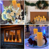 A close-up of glowing yellow and white LED candles arranged in a floral centerpiece on a glass dish.